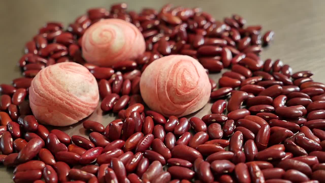 분홍색 중국 과자와 테이블에 빨간 콩을 닫습니다