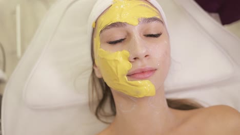 mujer recibiendo un tratamiento de máscara facial