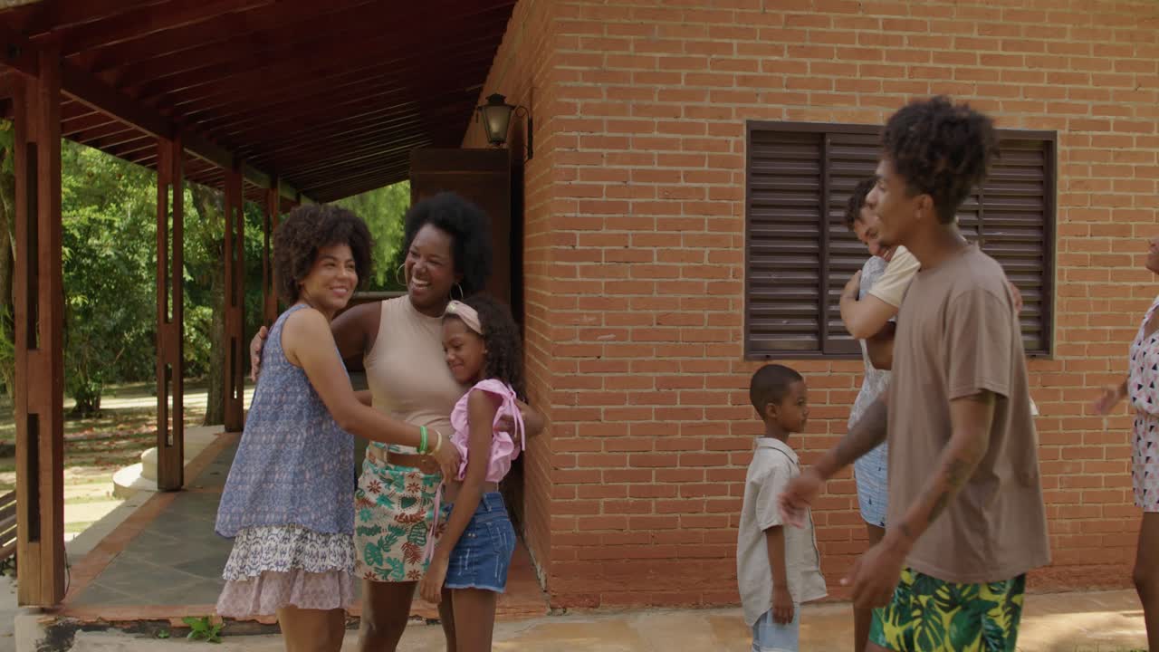 Family and friends happily greeting each other outside a home