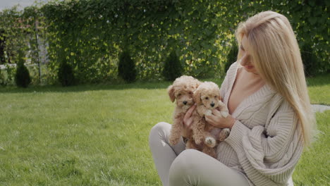 A-woman-with-a-bunch-of-puppies-sits-on-a-green-lawn.-Side-view