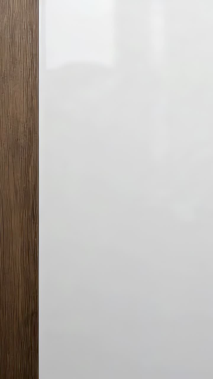 Video verticale: mostra un pannello chiaro che reagisce ai cambiamenti della luce ambientale nel corridoio di un ufficio, finiture in legno