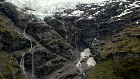 breathtaking scenic view of hanging glacier melting down in waterfalls from steep mountain