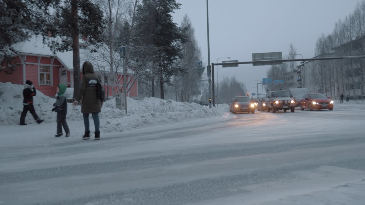 길을 가로질러 는 아이와 함께 어머니 겨울