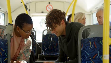 Couple-using-mobile-phone-while-travelling-in-bus-4k