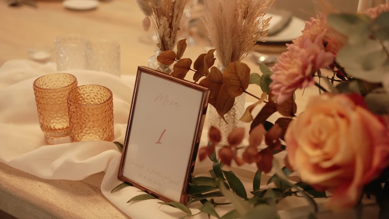 Table number with soft flower decor and amber glasses for wedding location irrelevant