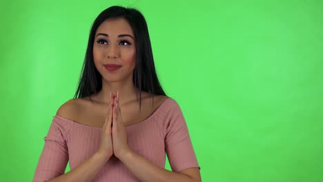 young attractive asian woman prays - green screen studio