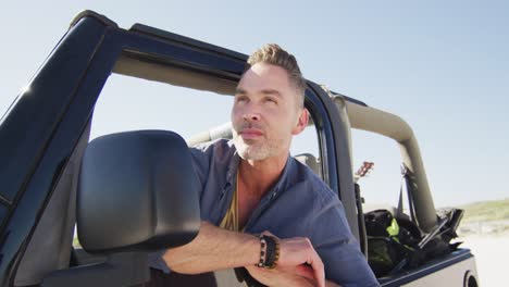 Happy-caucasian-man-in-car-admiring-the-view-on-sunny-day-at-the-beach