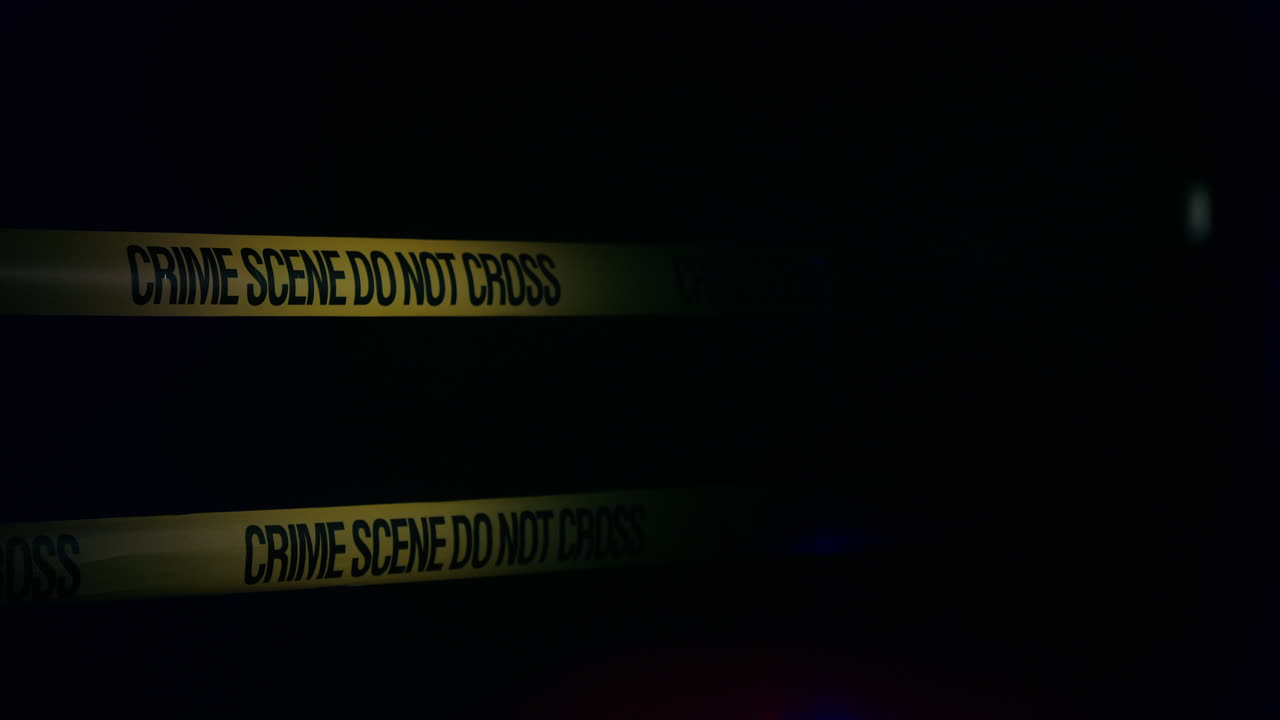 cintas amarillas encierran la escena del crimen iluminada por luces policiales 2