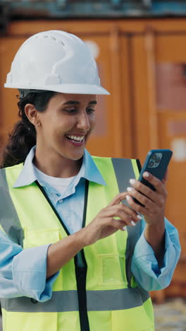 female engineer using smartphone in port