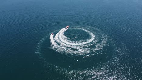 caribbean aerial: tourists enjoy bring towed on raft behind motorboat