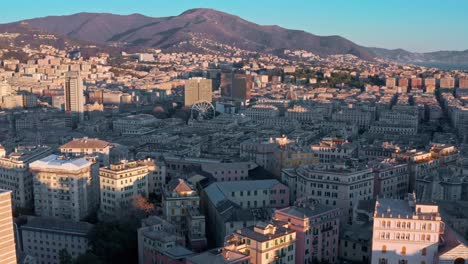 Aerial-sunset-view-over-Genova-skyline-with-ferris-wheel,-Liguaria,-Italy