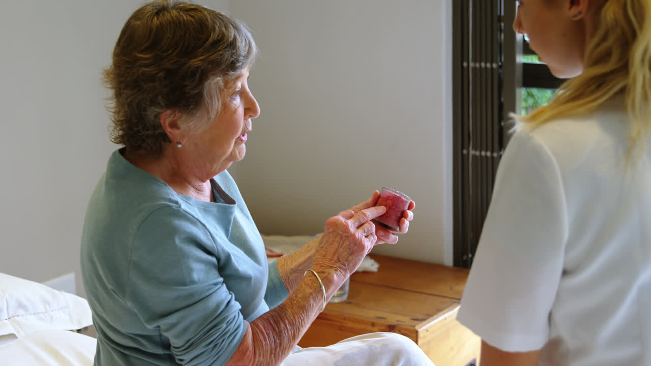 시니어 여성이 의사와 의학에 대해 논의합니다.