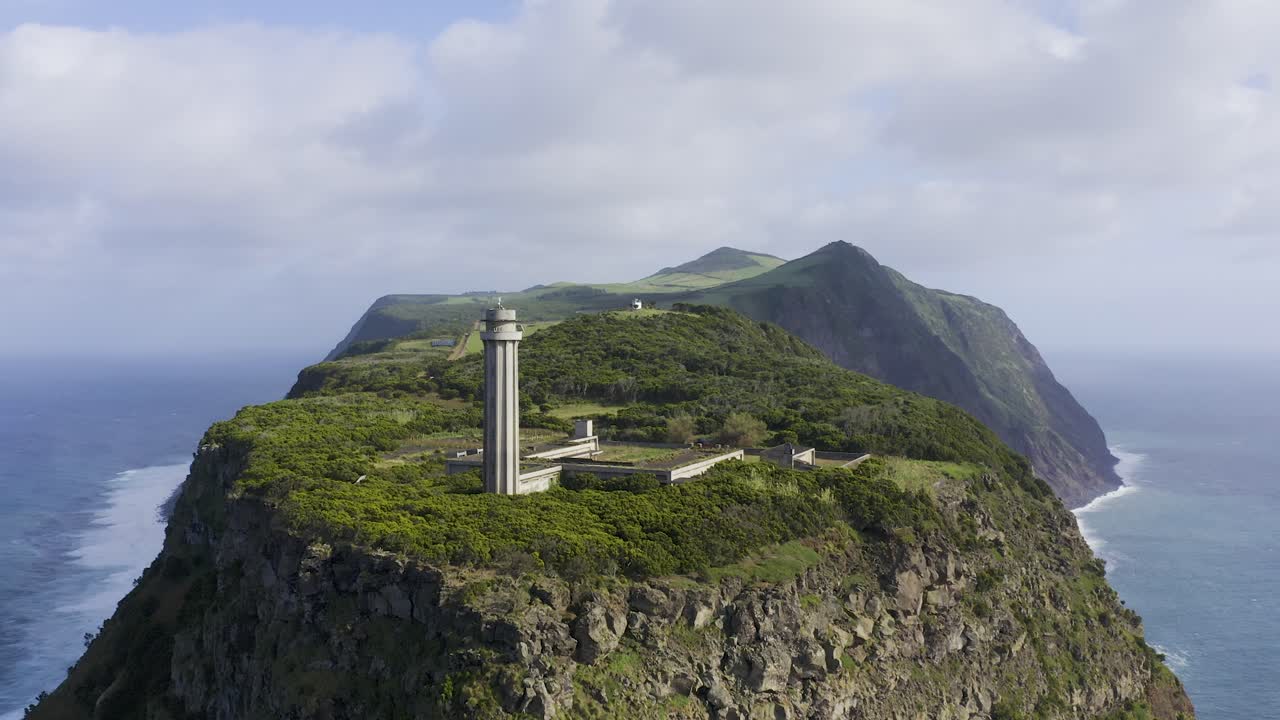 극적인 절벽과 대서양, 상조르제 섬 모양을 드러내는 등대의 무인 항공기 영상을 포르투갈 아조레스에서