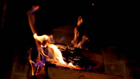 wooden logs burning in vivid flame in dark. burning fire in fireplace. warm fire flames in a country house. home hearth. close-up.