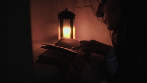 silhouette of woman reads mysterious night book with lantern