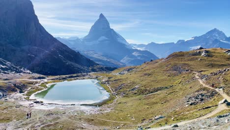 mountain freedom: matterhorn mountain landscape near rotenboden and gornergart, switzerland, europe | moving down trail as travel couple moves towards scenic lake, hiking