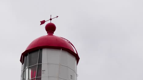 wind vane atop lighthouse rotating in the wind