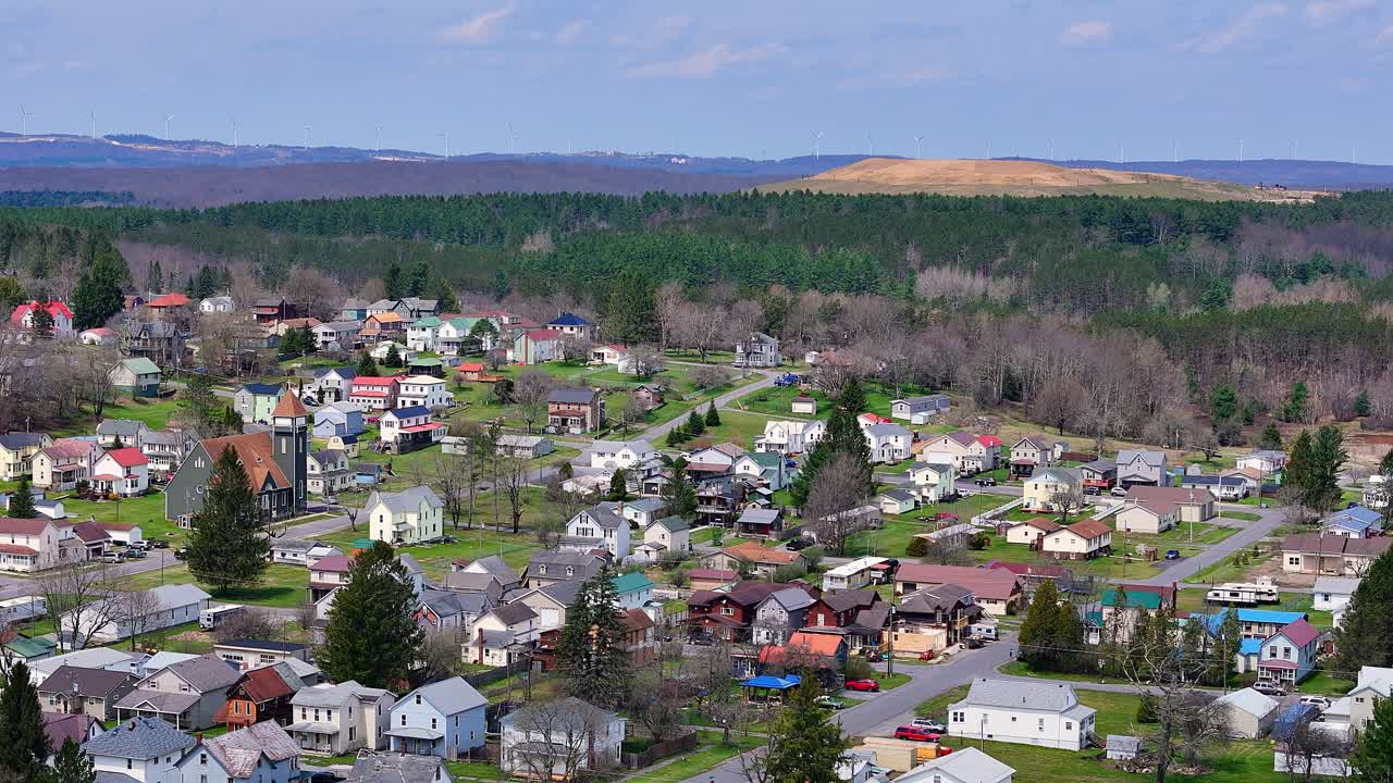 Colorful houses in hilly Davis, West Virginia with forested backdrop in spring, USA