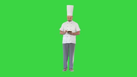 el chef masculino senior toma notas en una pantalla verde, llave de croma