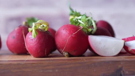 fresh red radishes on a wooden cutting board