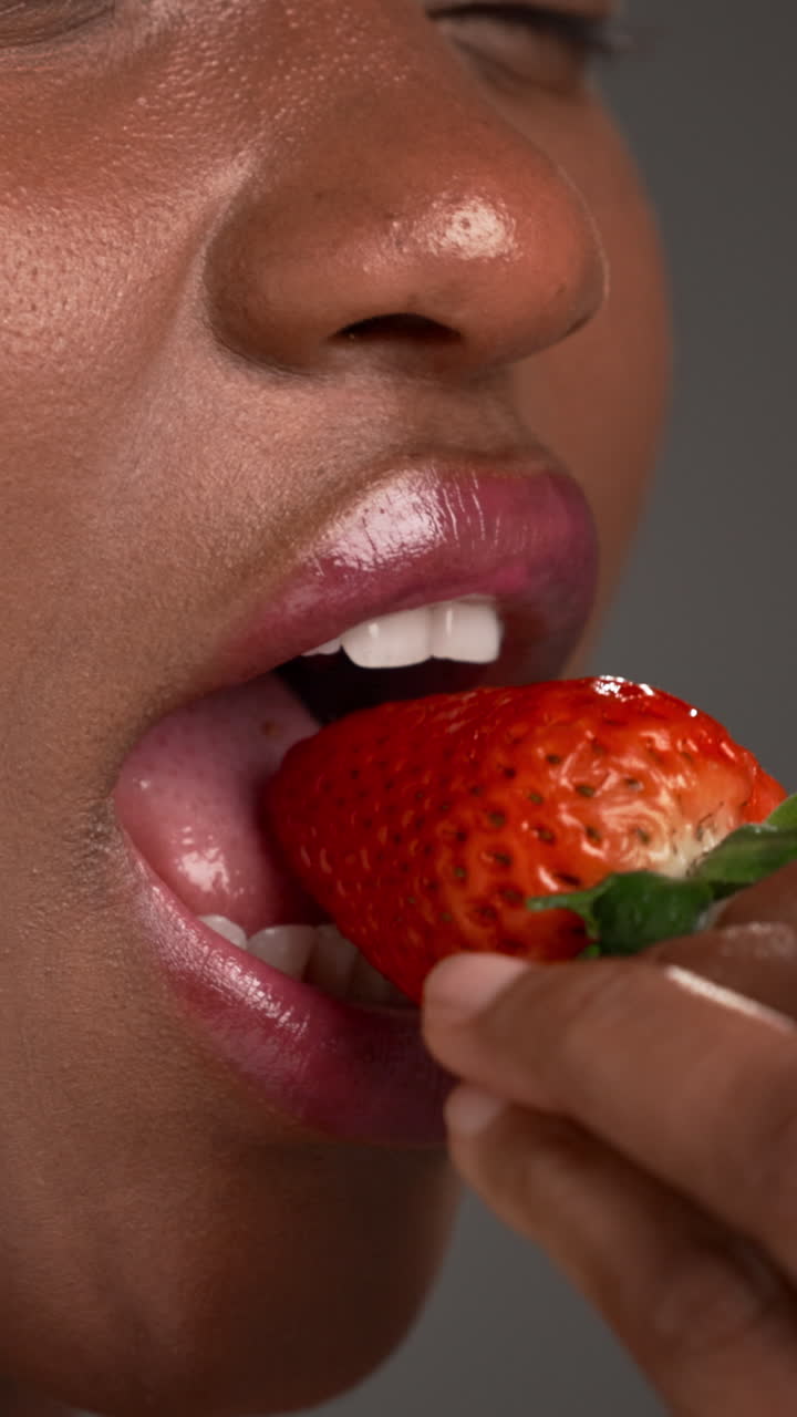 Uma pessoa comendo um morango