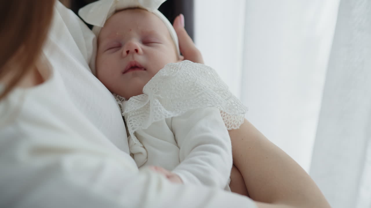 柔らかい白い布に包まれ、安らかに眠る乳児を抱きしめる優しい母親が、穏やかな雰囲気を作り出す