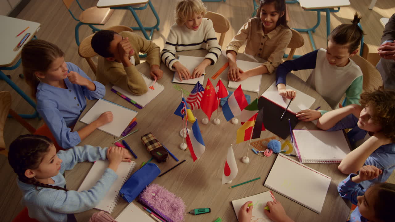 ученики на уроке географии. улыбающийся учитель объясняет задачу урока.