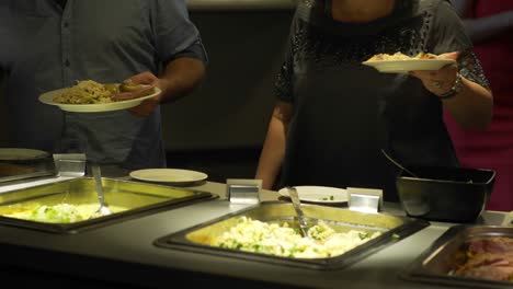 los huéspedes del restaurante eligen la comida de un buffet