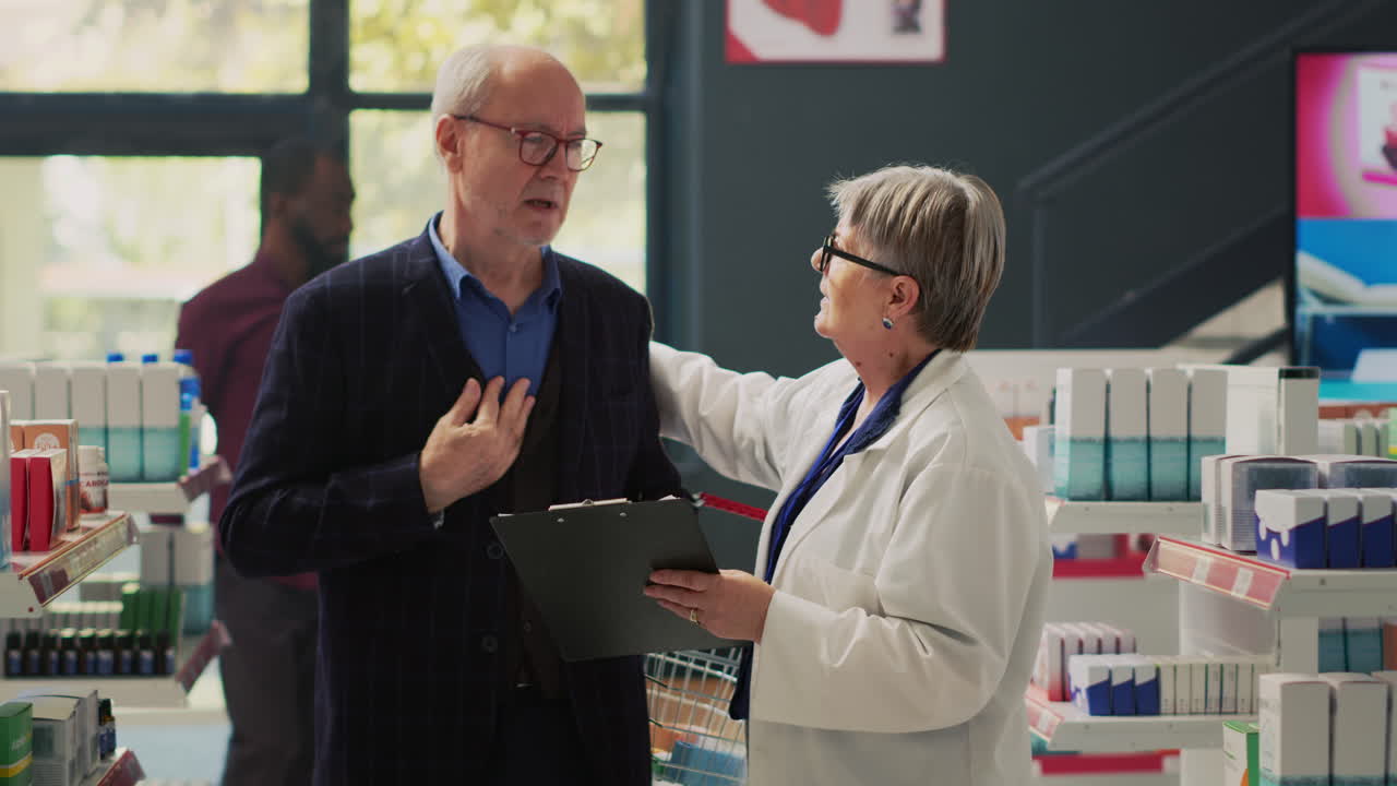 Senior man consulting with pharmacist about medication in pharmacy
