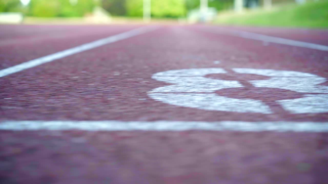 Partenza pista di atletica, ripresa panoramica fluida con conto alla rovescia da 10 a 1, in uno stadio olimpico vuoto