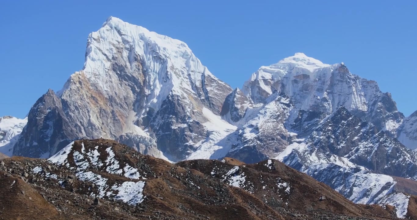 Everest-regionen Nepal, droneoptagelse, der vipper op og viser kontrasten mellem den snedækkede bred og det turkise vand i Gokyo-søen, og derefter afslører bjergtoppene.