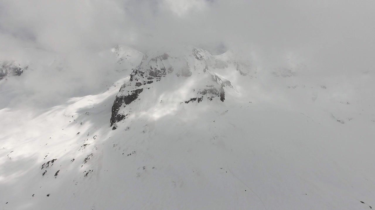 Vista Aérea de Pico de Montanha Nevado Entre Nuvens
