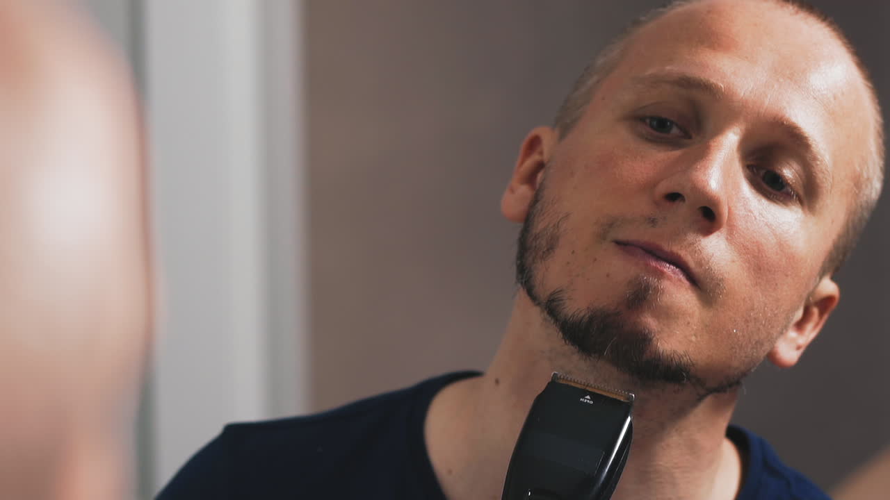 el joven sin afeitar se mira a sí mismo.