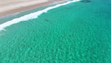 drone rising above smiths beach in margaret river, western australia