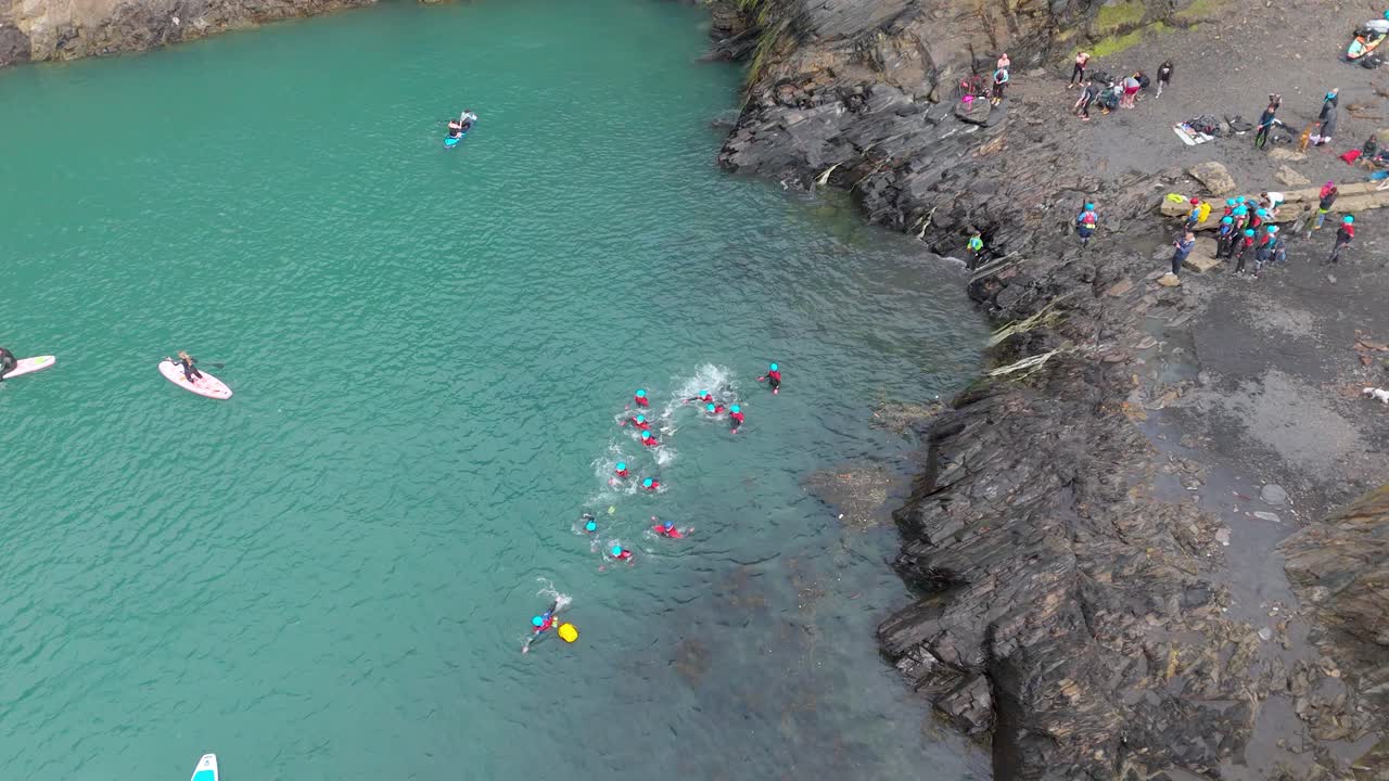 Coasteering Adventure: Group Jumping into Turquoise Water