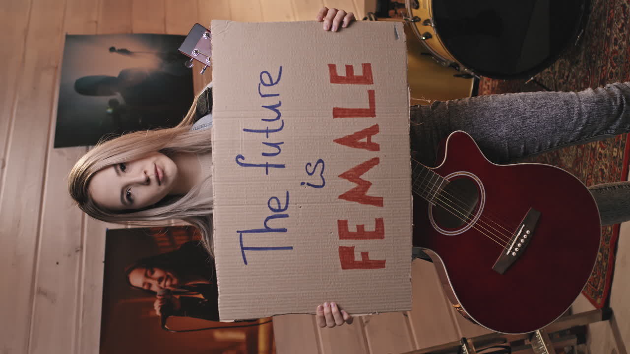 Female Guitarist Holding Future Is Female Sign