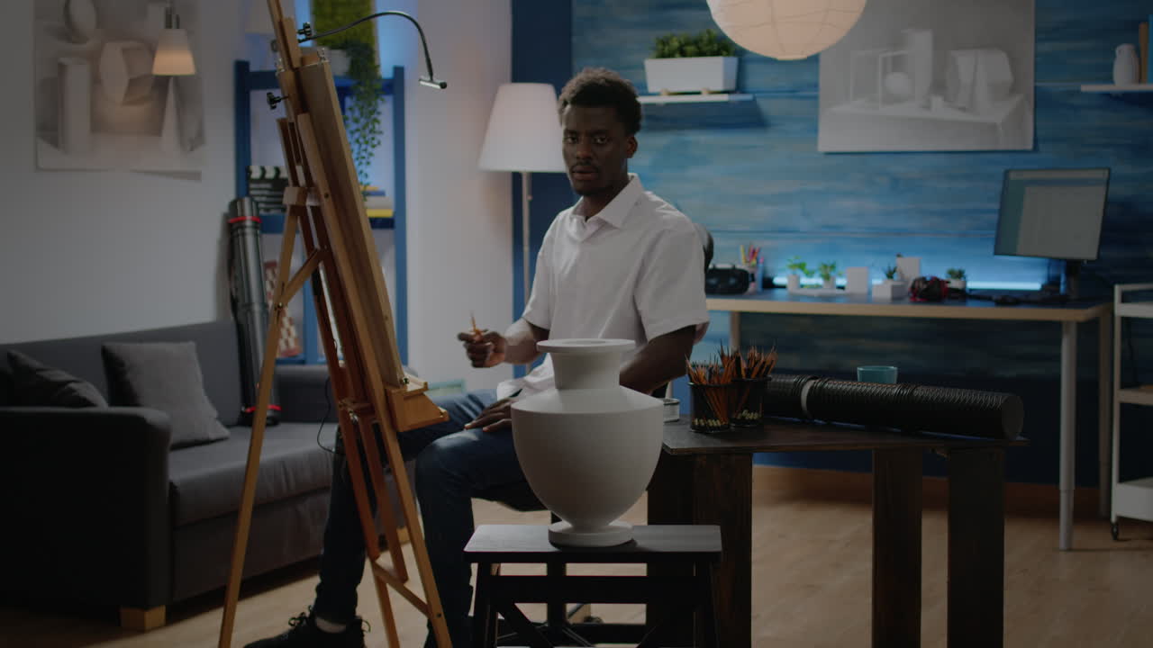 Artist of african american ethnicity analyzing vase