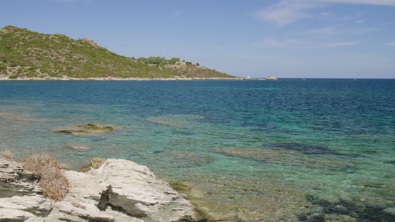 Saint-Florent Corsica coast sunny view of crystal clear turquoise waters northern Corsican seaside rocky shorelines under a bright blue sky serene Mediterranean landscape untouched natural beauty