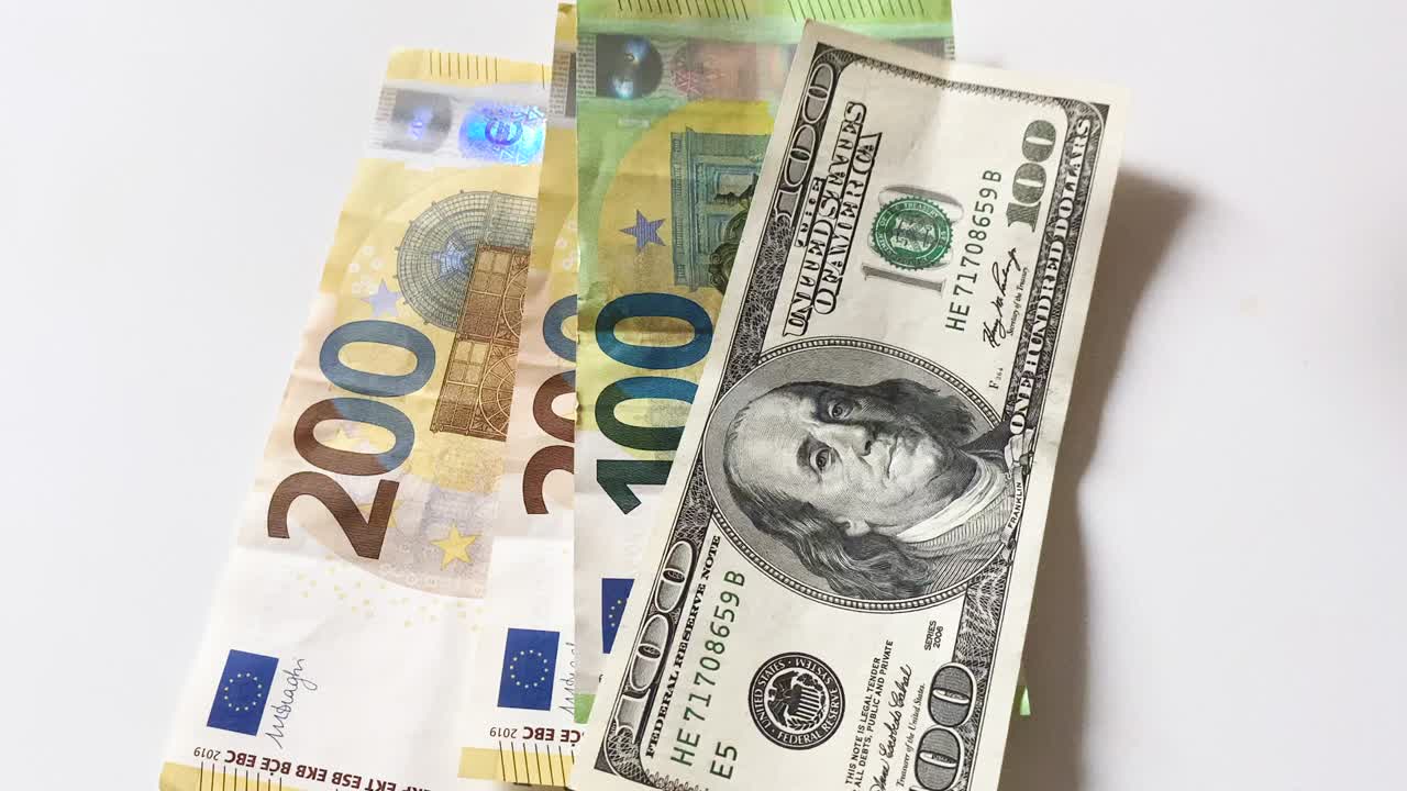 hombre contando dólares y euros.