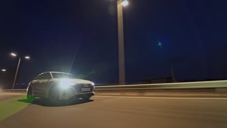 luxury car moving on the road at night. evening background on the highway and beautiful audi driving with bright headlights on.