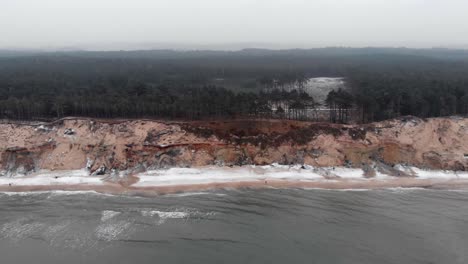 toma aérea de olas rompiendo en la playa de arena de ustka en invierno