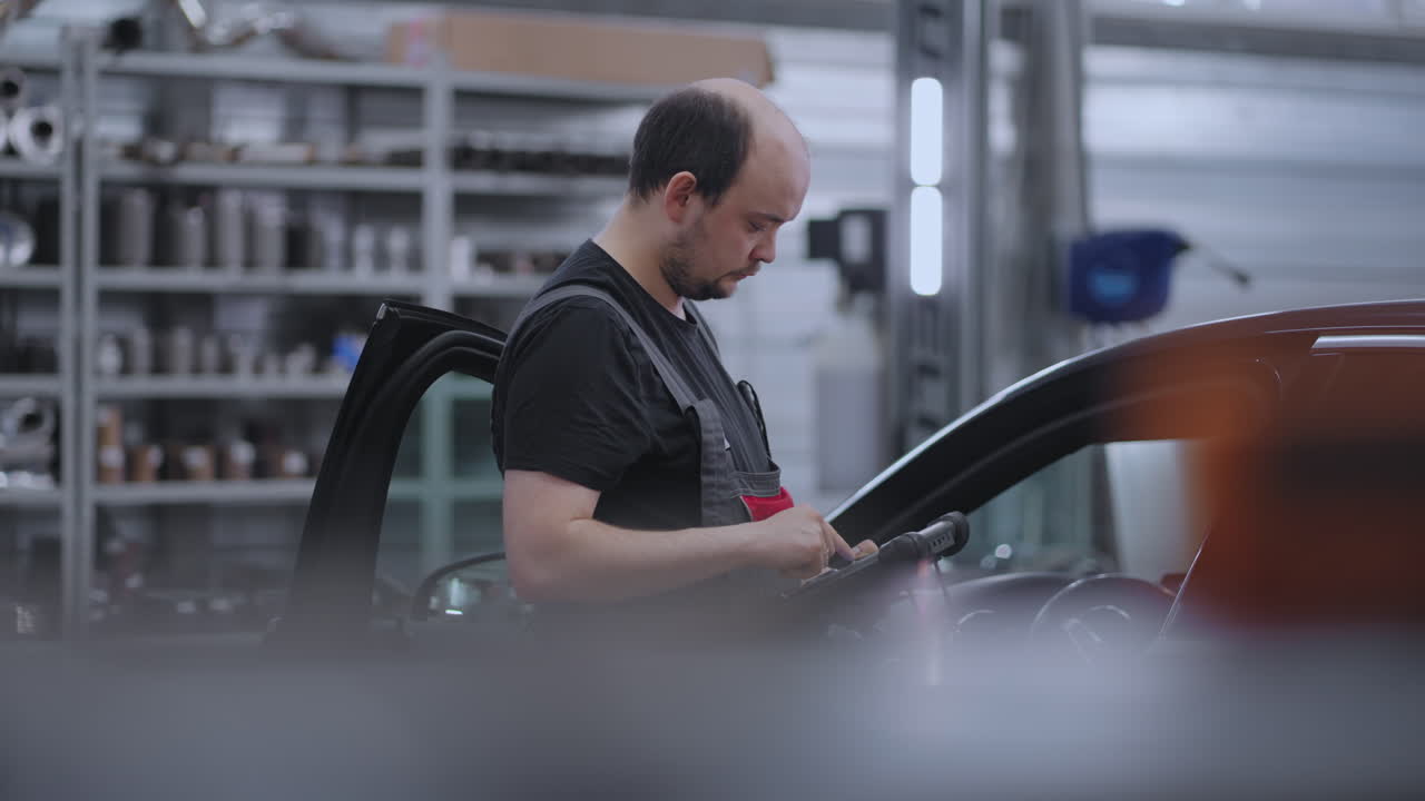 승인을 검색하고 자동차 고장을 진단하기 위해 디지털 태블릿을 사용하는 기계. 차량 수리, 자동차 서비스 및 트럭의 유지 보수에 대한 기술의 사용. 자동차 기계