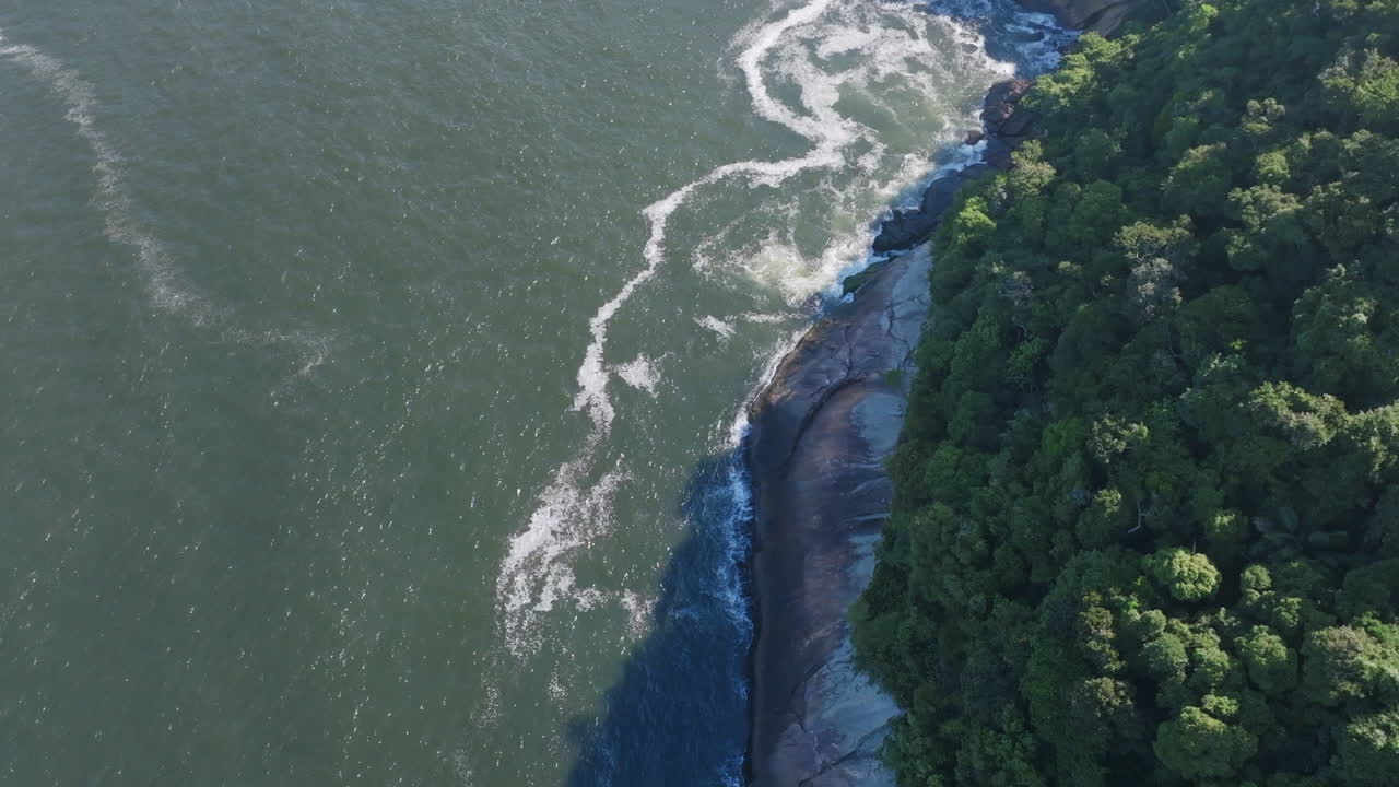 imágenes aéreas volando sobre las aguas del océano atlántico arrastrándose contra las rocas fuera de la ciudad de río de janeiro