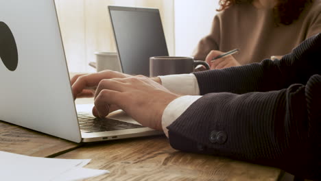 close up of two unrecognizable business people debating while using laptop computer 1