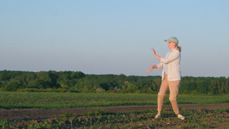 woman practicing tai chi in a field at sunset