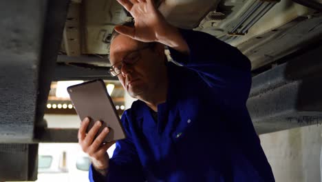 mechanic using digital tablet while examining a car 4k