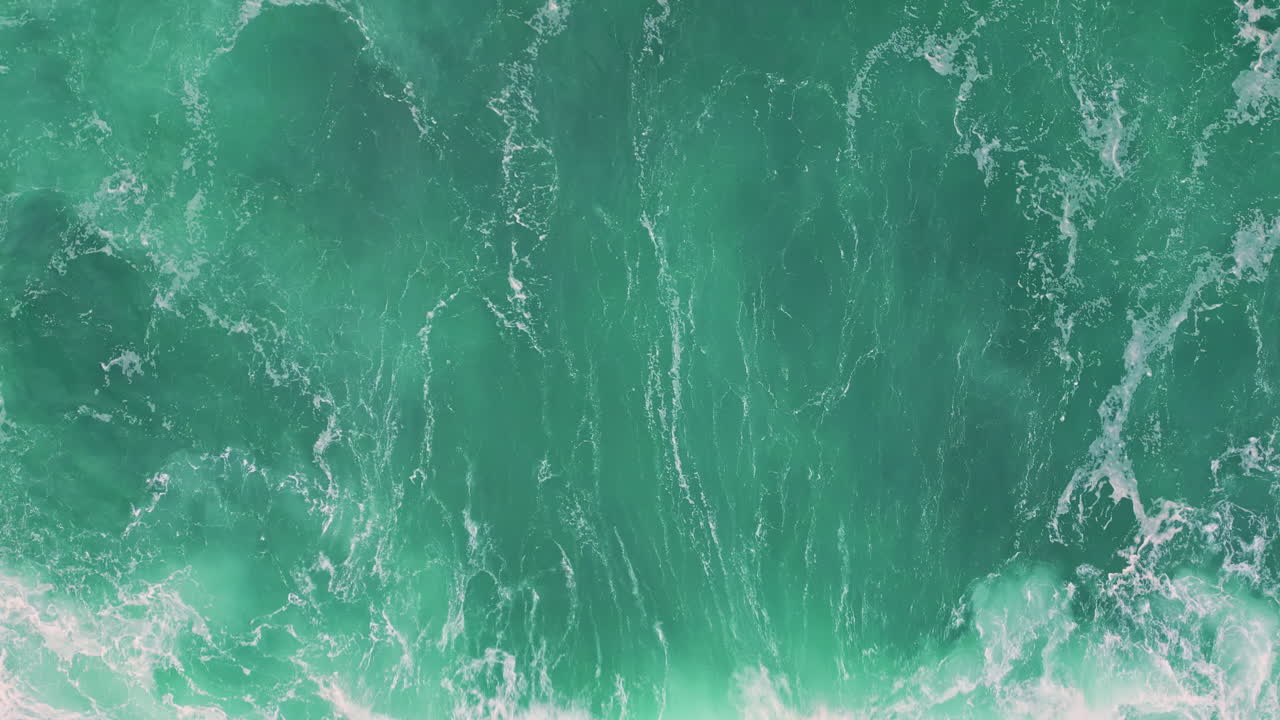 Top azure ocean water rippling with white foam. Vibrant turquoise waves rolling