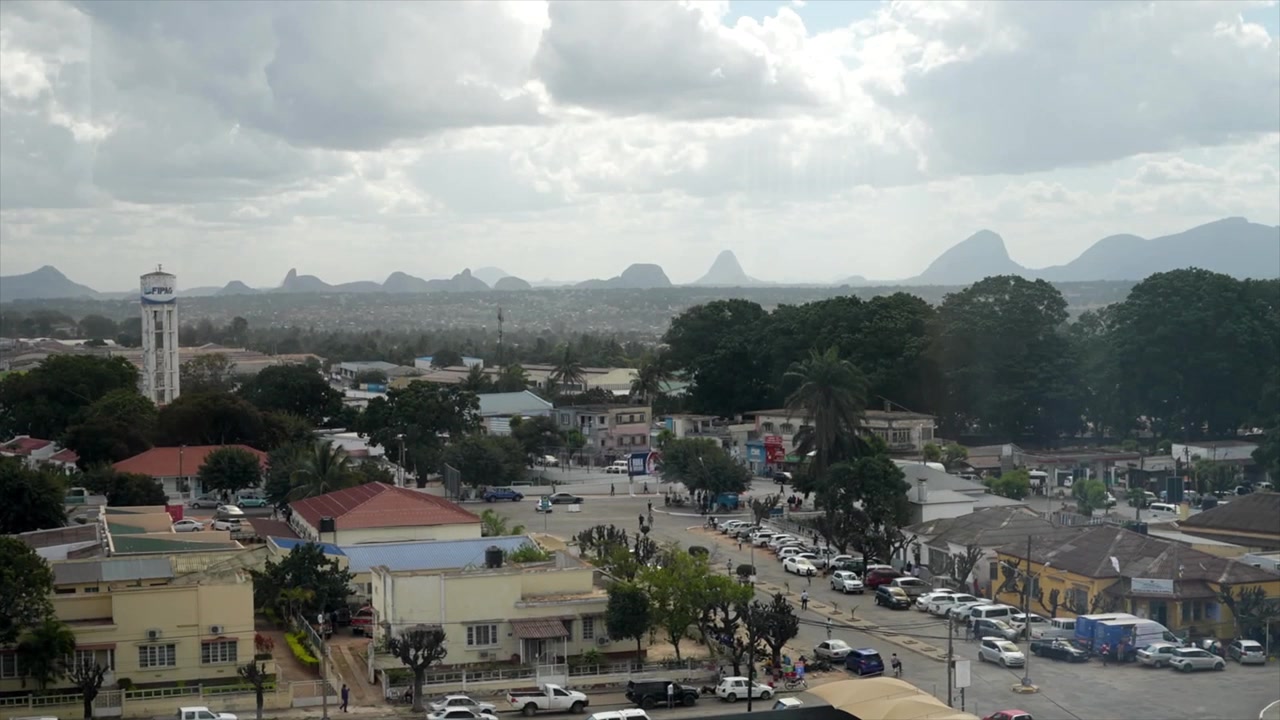 Thành phố Nampula ở phía bắc Mozambique, nhìn ra đường chân trời đô thị, đường phố và thảm thực vật tươi tốt, nằm dựa vào những ngọn núi hùng vĩ dưới bầu trời ảm đạm, bão tố.