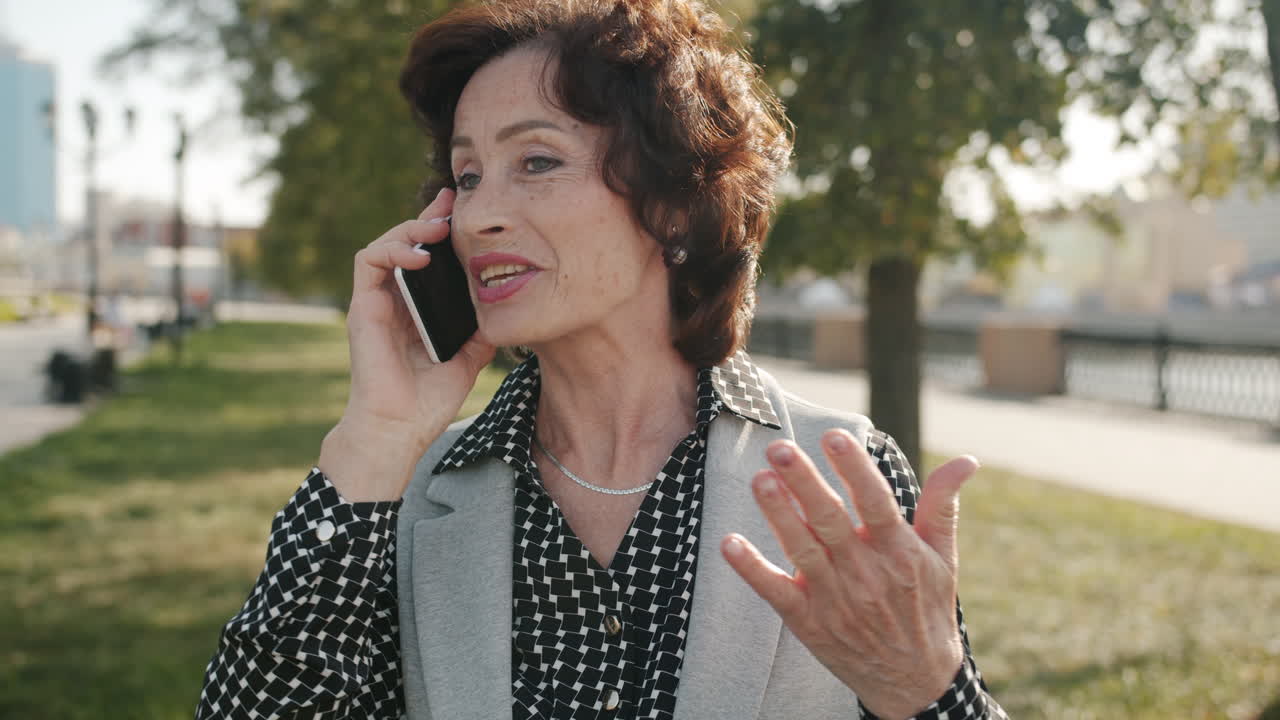 Senior Woman Talking on Phone in Park