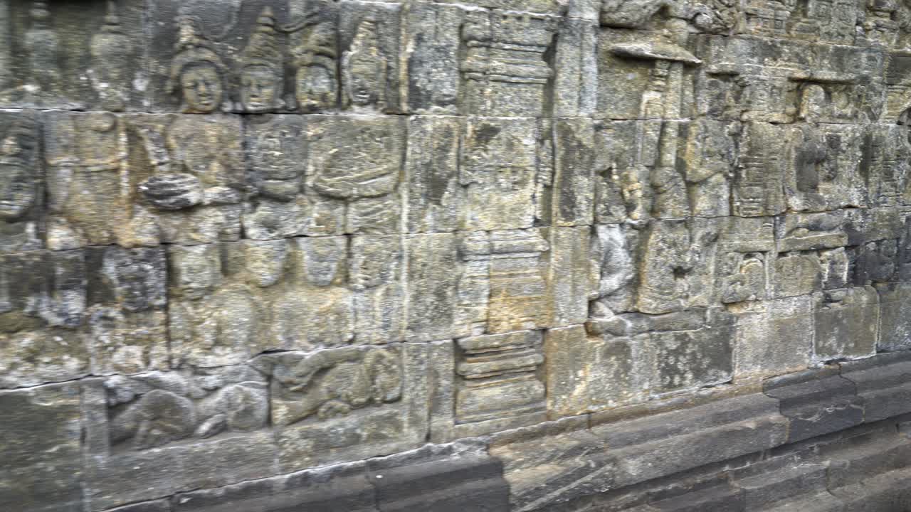 Indonesia,Jawa Island,Yogyakarta,Unesco world heritage Borobudur Temple's inside,wall reliefs, Camera slides slowly from left to right and shows the relief in details, ancient stories on the wall.